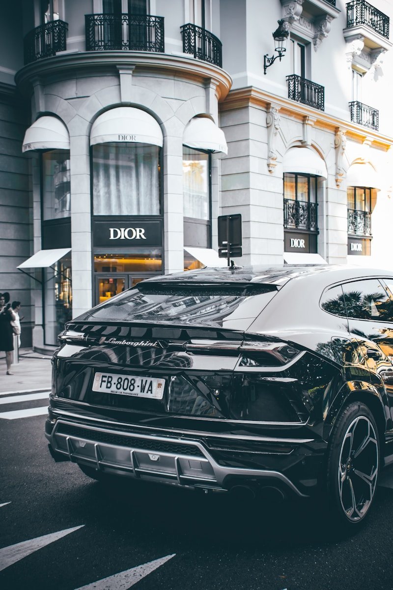 Automóvil negro frente a una fachada elegante, imagen de la web original